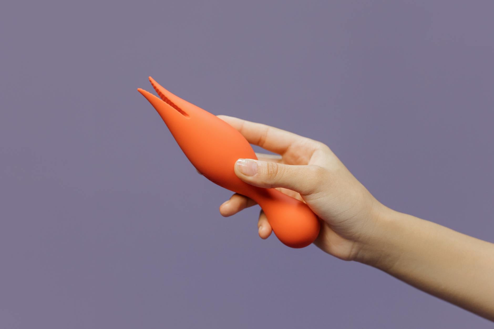 Close-up of a vibrator held against a minimalistic backdrop, representing the beginning of pleasure reconnection.